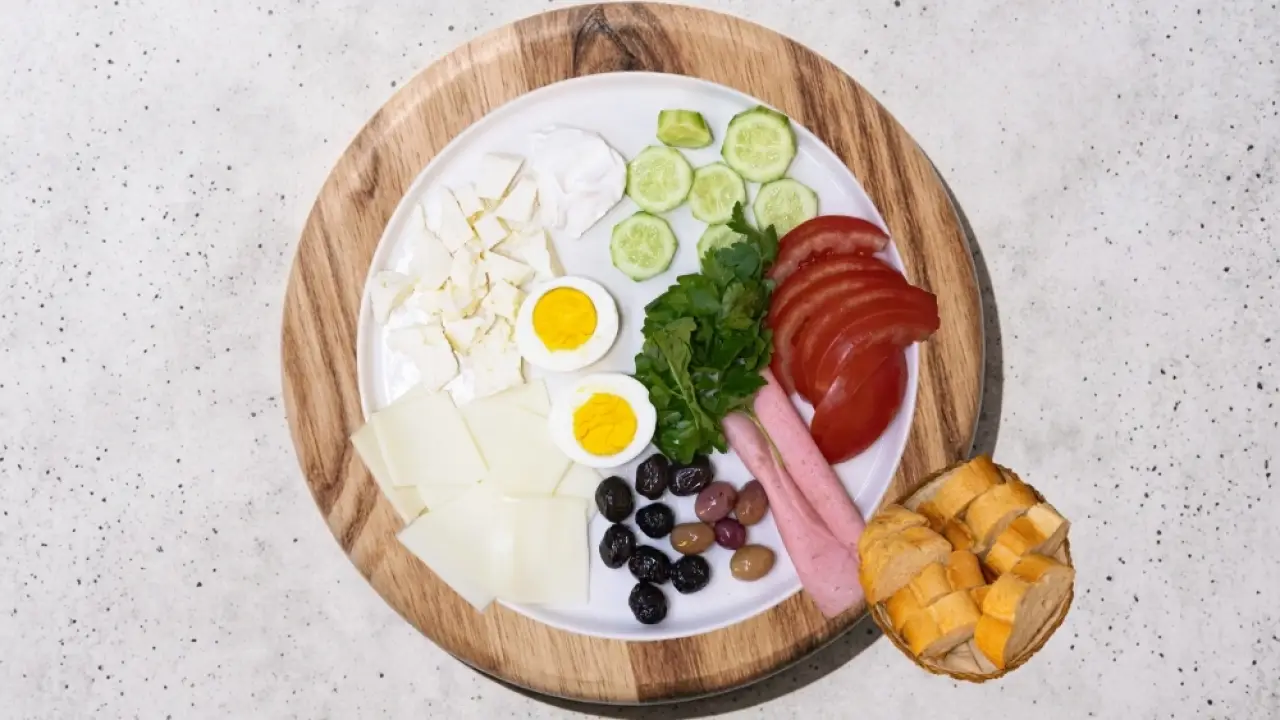 Peynir, yumurta, zeytin, domates, salatalık ve ekmek içeren kahvaltı tabağı